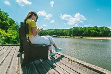 Fototapeta premium young pretty woman sitis on the bench