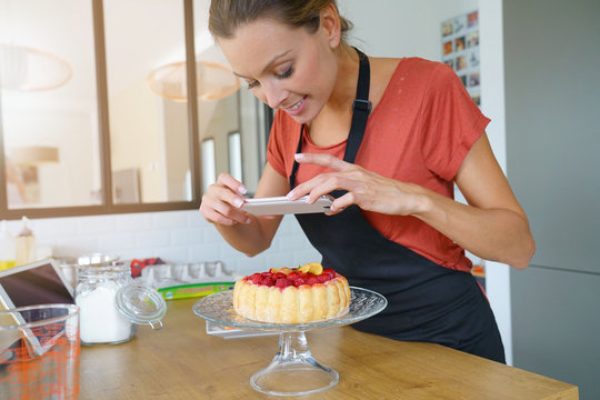 Blogger taking picture of cake to upload on website