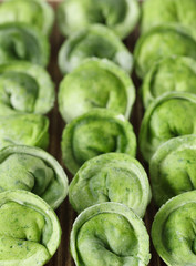 Fototapeta premium dumplings of spinach on wooden boars. Rolling pin and spices.