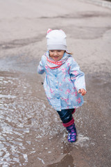 Little girl running to the puddle