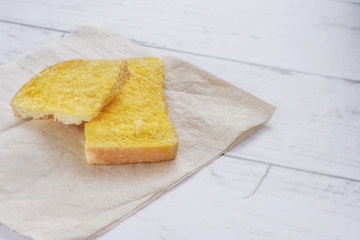 Crispy bread butter sugar on brown tissue paper on wooden table