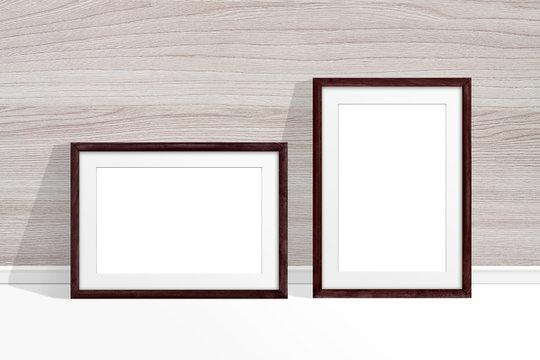 Two blank photo frames near wooden wall, decor mockup