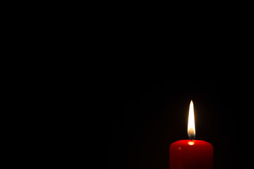 One red color candle light on black background