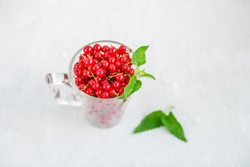Delicious Red Currant with Mint on a White Background. Top view. The concept is healthy food, vitamins, diet and vegetarianism.