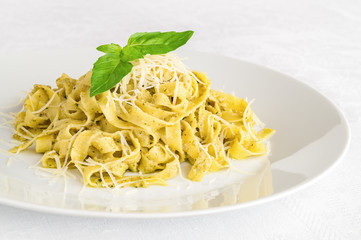 fettuccine pesto decorated with basil leafs