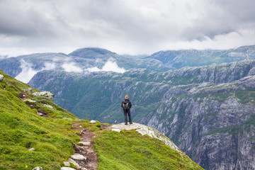 Fototapeta na wymiar Happy people relax in cliff during trip Norway. hiking route