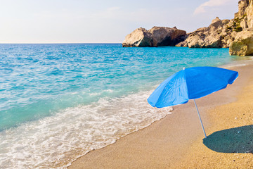 Fototapeta na wymiar Blue parasol on sunny Kathisma beach