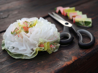 Flowers handmade from napkin on wooden table. Step by step photo instruction.