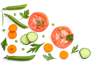 sliced tomatoes, sliced carrot, sliced cucumber, parsley and fresh green peas isolated on a white background. top view