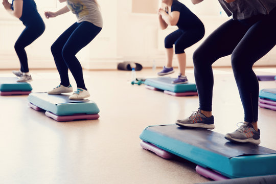 group of girls is engaged in a step on the stand - fitness. The concept of maintaining health, walking.