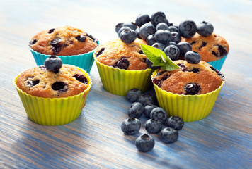 muffin with blueberries on a wooden table. fresh berries and sweet pastries on the board.