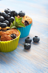muffin with blueberries on a wooden table. fresh berries and sweet pastries on the board.
