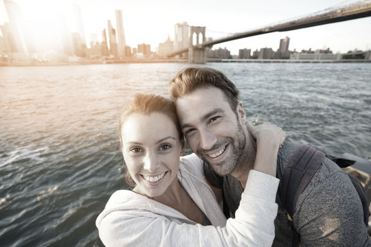 Couple embracing each other, Brooklyn bridge in background