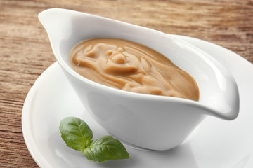 Sauce boat with turkey gravy on wooden background