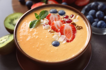 Bowl of fresh yogurt smoothie with fruits on grunge background