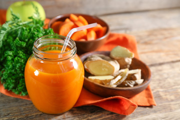 Jar of carrot juice on wooden table