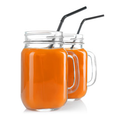 Mason jars of delicious carrot juice, on white background