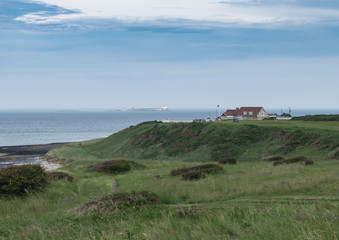Fototapeta na wymiar Bamburgh Castle golf club with Farne Islands in the distance