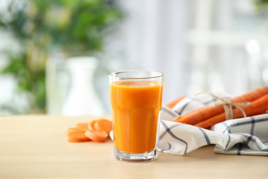 Glass of fresh carrot juice on light table in the kitchen