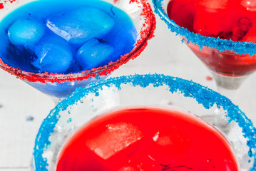 Treats for Independence Day holiday on July 4. Homemade alcoholic cocktails, punch in traditional colors - red, blue, white. With ice. On the home kitchen table. Copy space close view