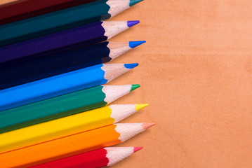 Color pencils on wood background close up