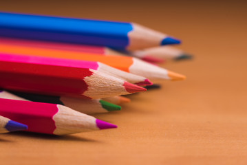 Color pencils on wood background close up
