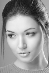 Fototapeta premium Portrait of young brunette woman with clean skin on an isolated background black and white image