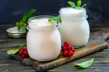 Jars with melted sour milk and natural yoghurt.