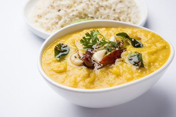 Indian popular food Dal fry or traditional Dal Tadka Curry served with jeera rice, isolated over white background, selective focus © StockImageFactory