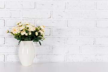 flowers on the table over white brick wall