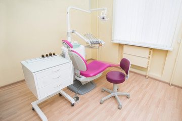 Modern dental office interior. Dental chair and other medical accessories used by dentists.