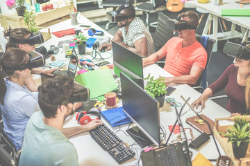 Young teamwork using virtual reality glasses in creative office - Business casually dressed people...