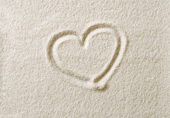 Fototapeta na wymiar Heart symbol drawn in sand surface. Heart shape, an ideograph to express emotion like romantic love. Metaphoric. Macro photo close up from above.