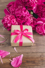 Row of peonies on wooden background with space for message. Women's or Mother's Day background. Top view