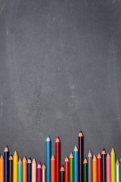 blank chalkboard with colored pencils alongside
