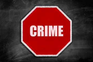 crime written on  a stop sign on a black chalkboard