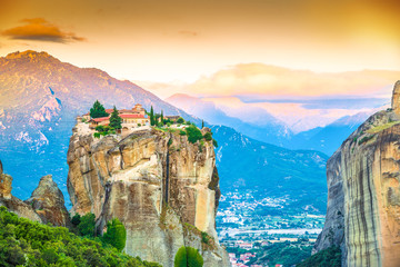 Panorama at sunset over mountain peak and Holy Trinity monastery in Meteora place in Greece, Europe - obrazy, fototapety, plakaty