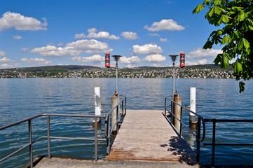 Schiffsteg von Kilchberg - Schiffanlegestelle am Zürichsee. Mit blauem Himmel und weissen Wolken am Himmel