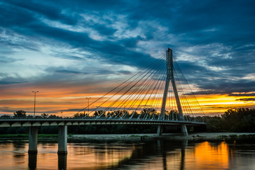 Fototapeta na wymiar Sunrise on the Swietokrzyski bridge over the Vistula river in Warsaw, Poland