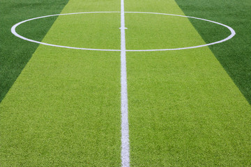 Obraz premium Photo of a green synthetic grass sports field with white line shot from above.