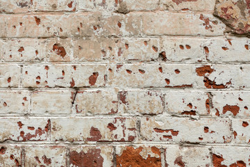 dirty brick wall with peeling plaster