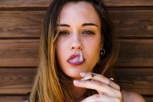 Close up of young woman smoking cigarette 
