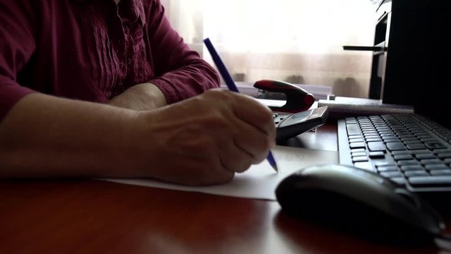 Accountant working with data sheet and using calculator