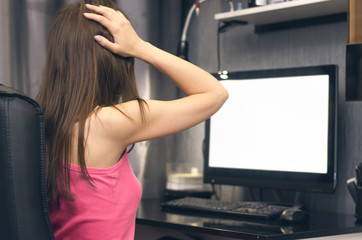 The girl working on computer with blank screen monitor and holding her hands on the head. Lack of time concept or big sale concept.