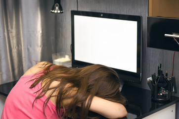 Girl was asleep sitting at the computer with blank screen monitor. Lack of time concept, tiredness concept, boredom.