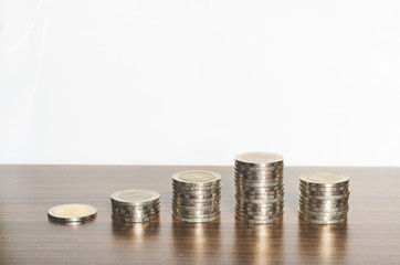 coins step up to grow on wood board with white background. success concept money financial saving.