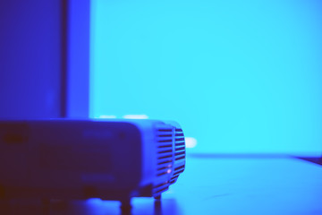 Screen with blue light from projector in the dark meeting room