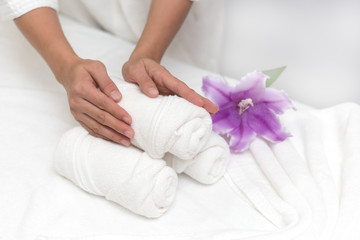 Obraz na płótnie Canvas Hands of woman setting wellness decoration in spa salon background