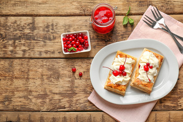 Tasty puff pastry dessert with berries and whipped cream on plate