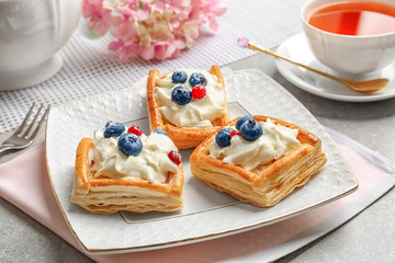 Plate with delicious pastries on pink napkin